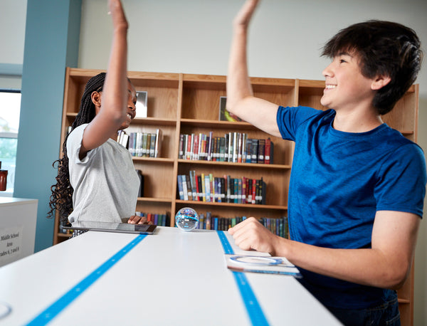 Two students high five.