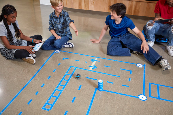 Students program BOLT+ robots through a maze.