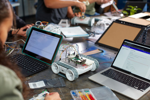 A RVR+ and laptops with code on a desk.