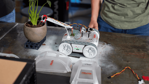 Students program a micro:bit throwing arm on top of a RVR+ robot.