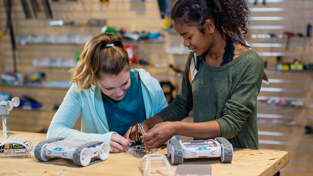 Two high school girls work on a Sphero robot as a back to school activity.
