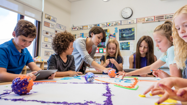 Teacher helping students with Sphero painting activity.