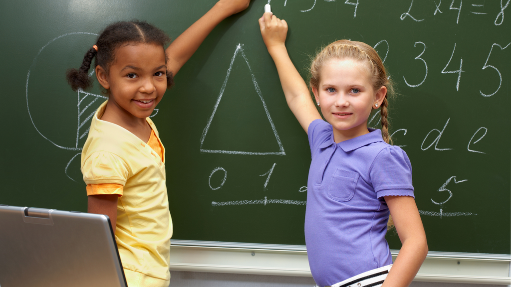 Two girls work on critical thinking and problem solving, which are valuable coding skills for kids.