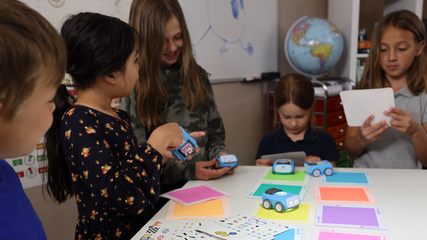 Early learners work with Sphero indi at a large table.