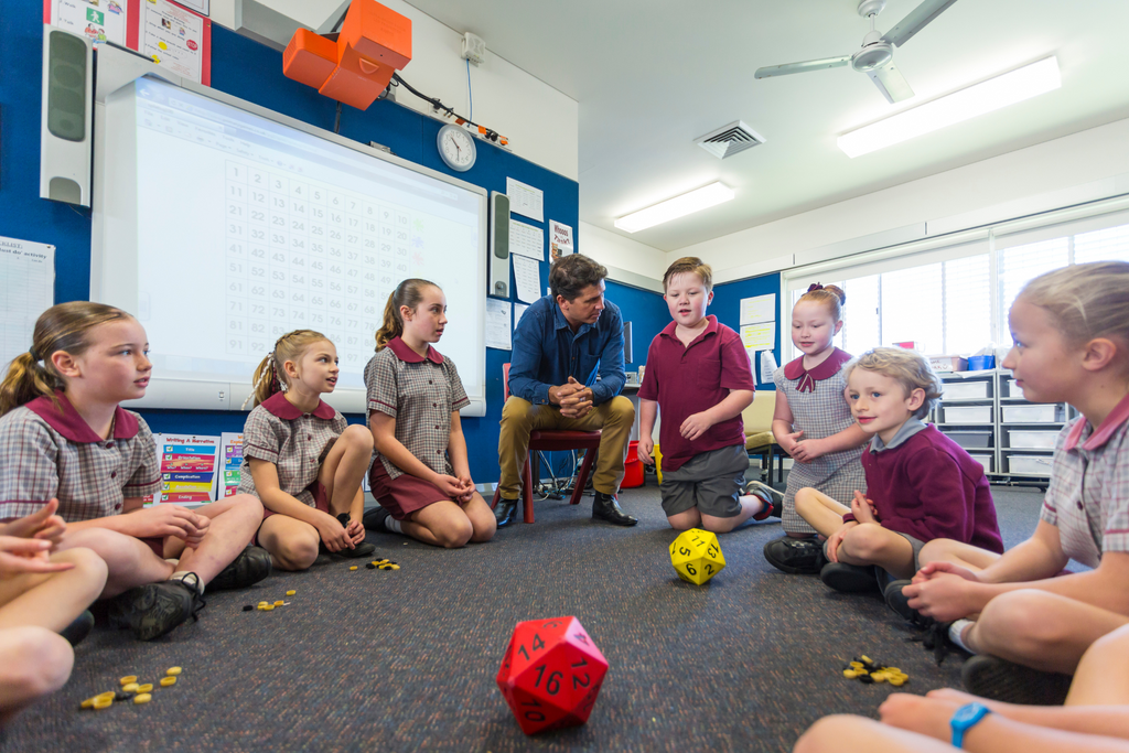 Students in a classroom playing a game with dice.