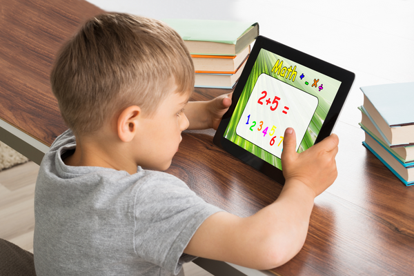 A kid plays a math game on a tablet.