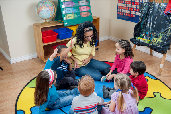 A class sitting in a circle on a carpet having a discussion.