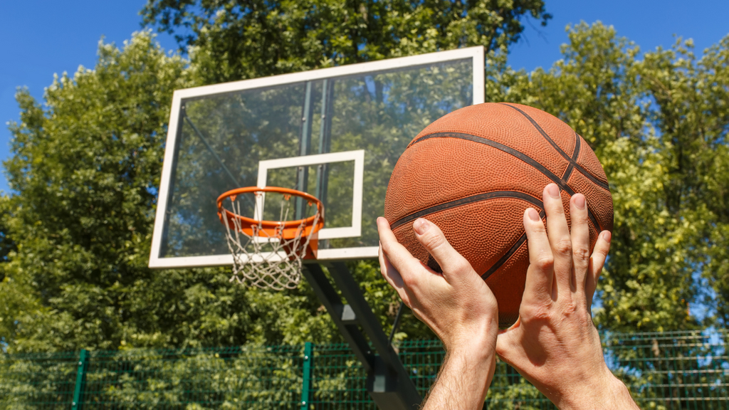 Hands aiming to throw a basketball.